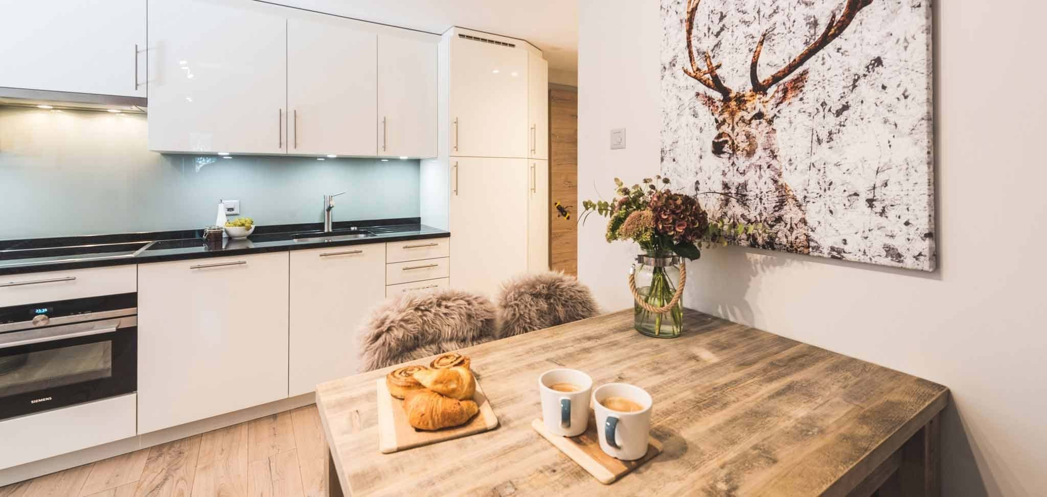 Kitchen with induction cooktop and wooden dining table for four