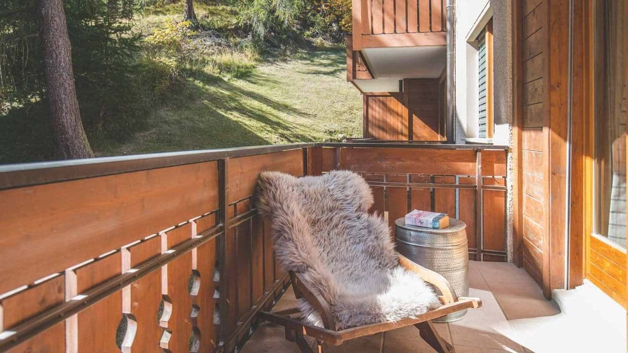 Private balcony with lounge seating and forest views