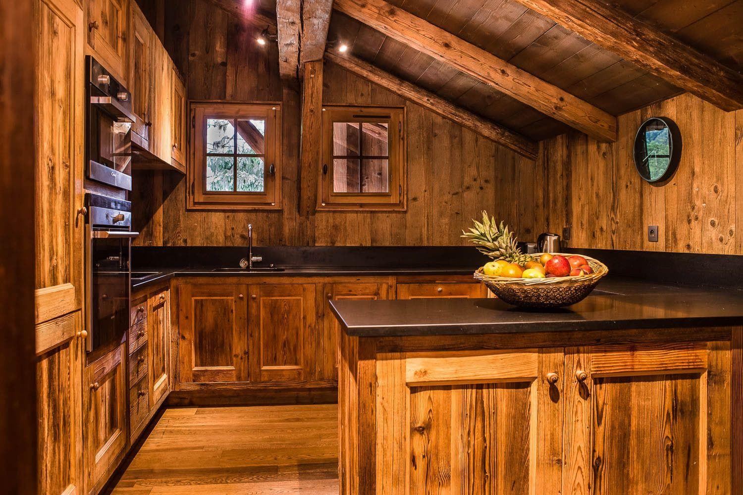 Kitchen with reclaimed wood cabinetry, double wall ovens, and stone counters