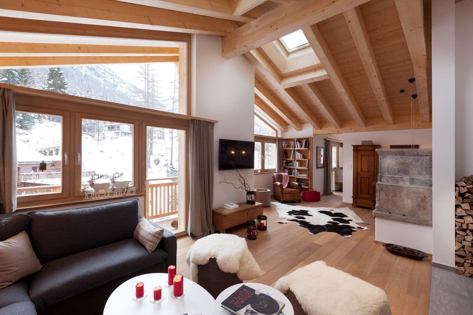 Living area with vaulted wood ceilings, stone fireplace, and mountain views