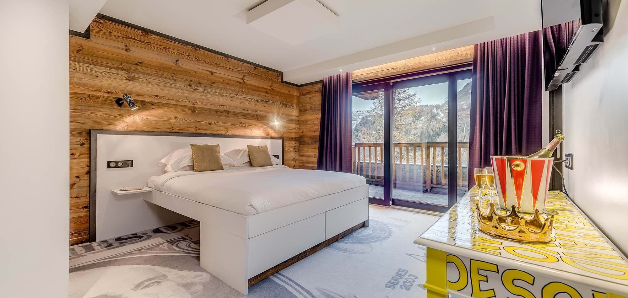 Primary bedroom with king bed, mountain views, and direct balcony access