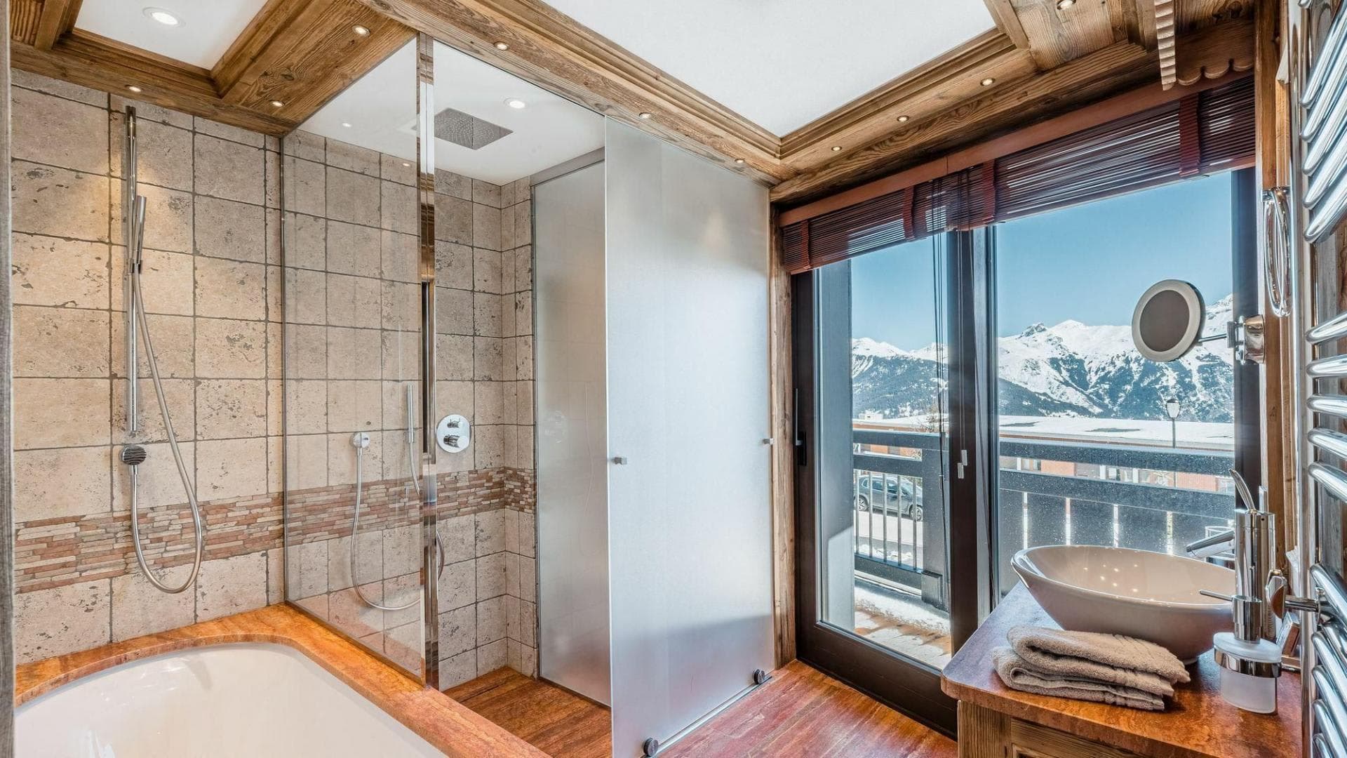 Bathroom with walk-in rainfall shower, soaking tub, and mountain views