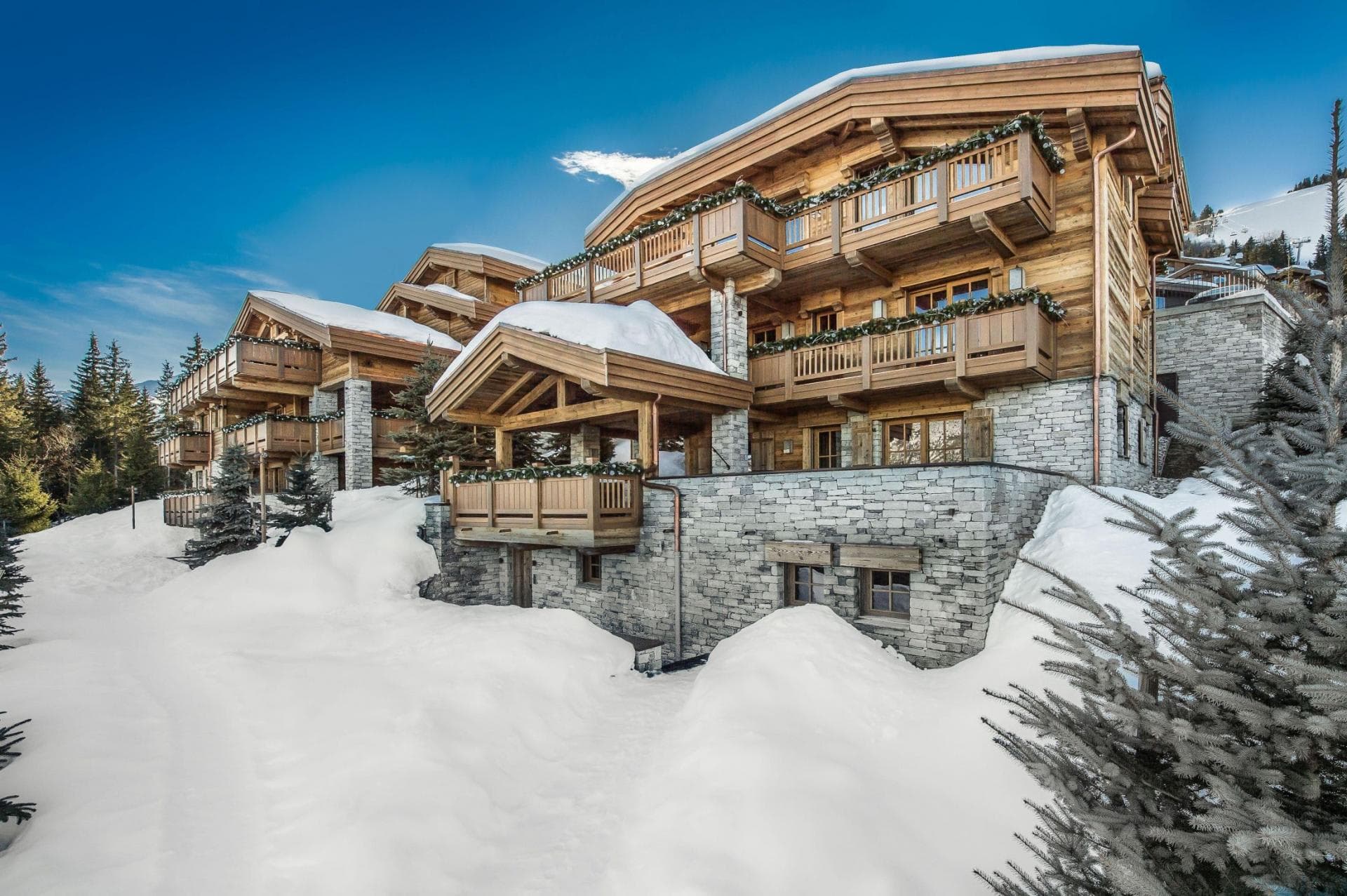 Ski-in, ski-out timber chalet with private balconies and stone masonry