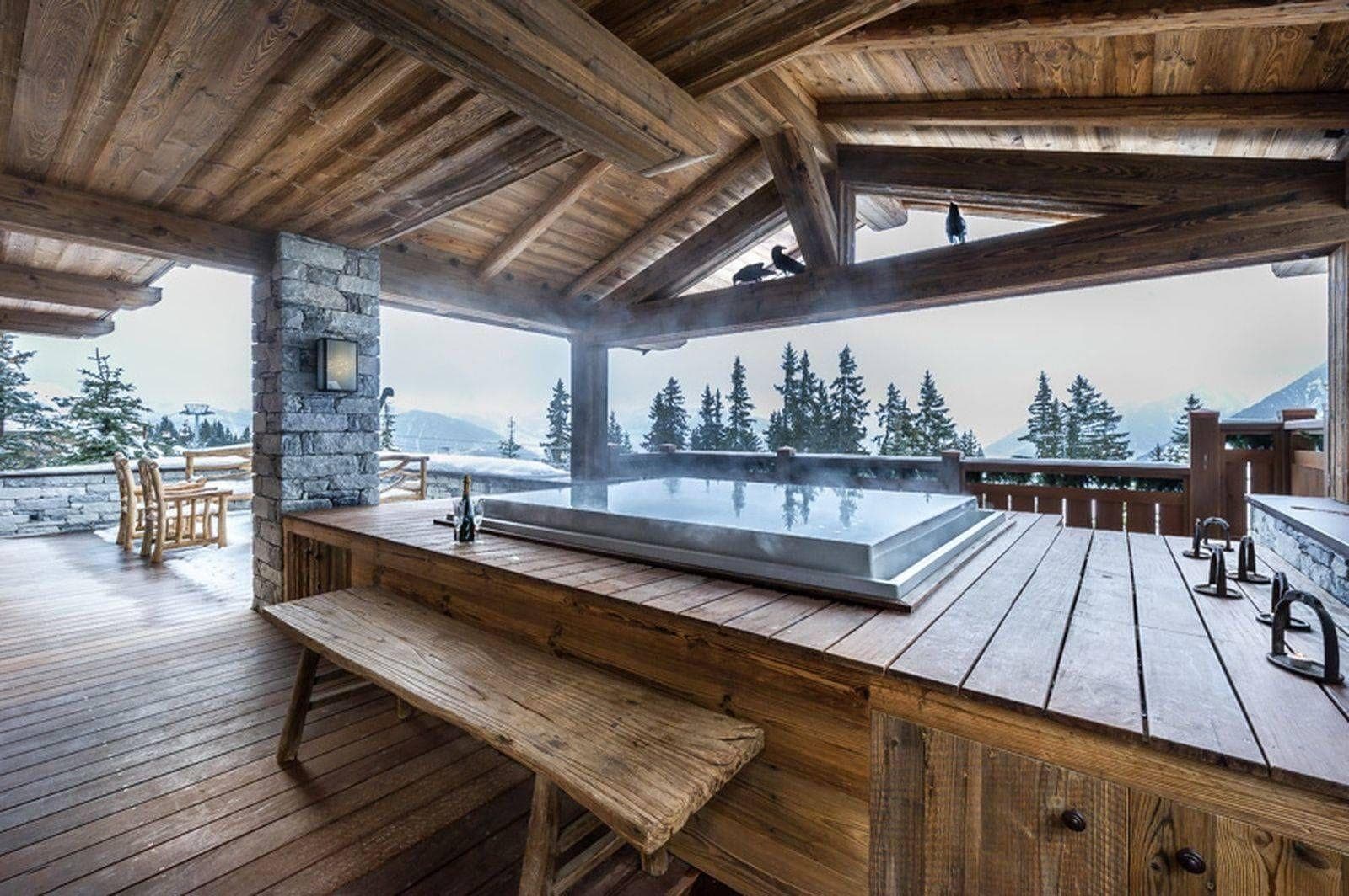 Covered outdoor hot tub with mountain views and built-in bench seating