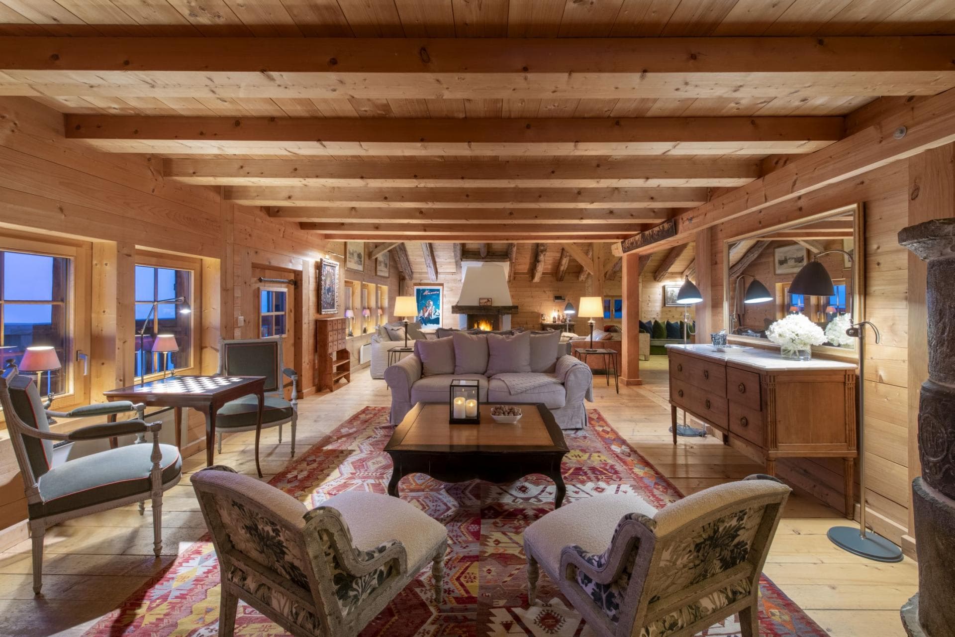 Open-plan living area with wood-beam ceilings and wood-burning fireplace
