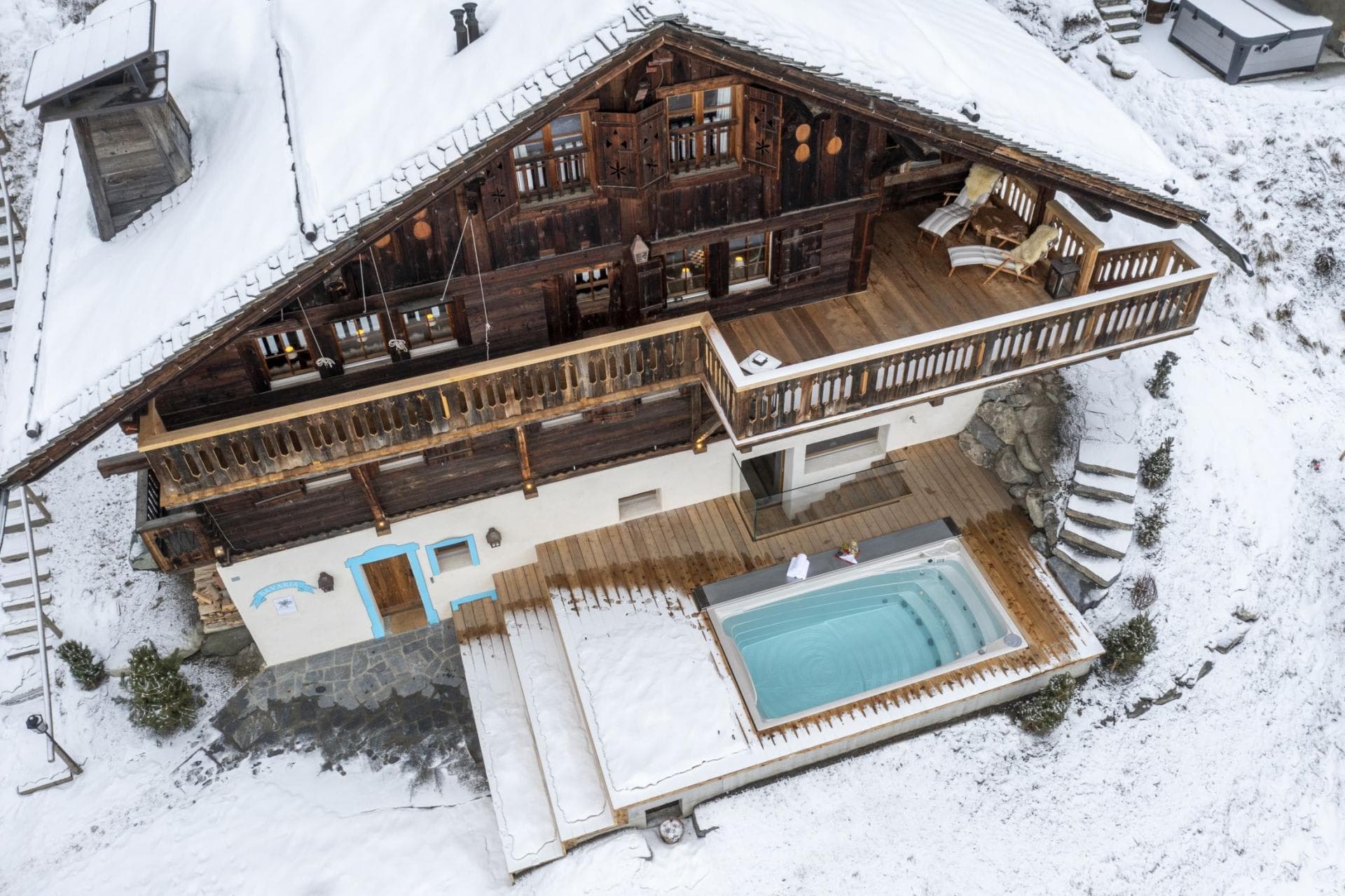 Chalet exterior with heated outdoor pool and upper-level sun deck