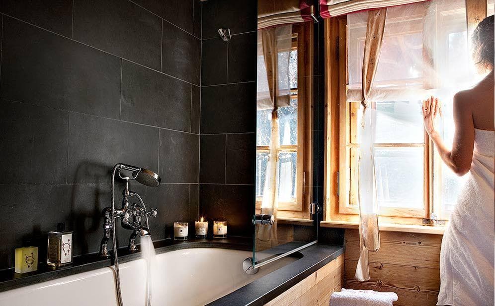 Bathroom with slate tile, soaking tub, and handheld shower attachment