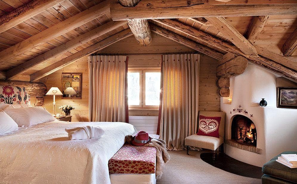 Attic bedroom with wood-burning fireplace and exposed timber beams