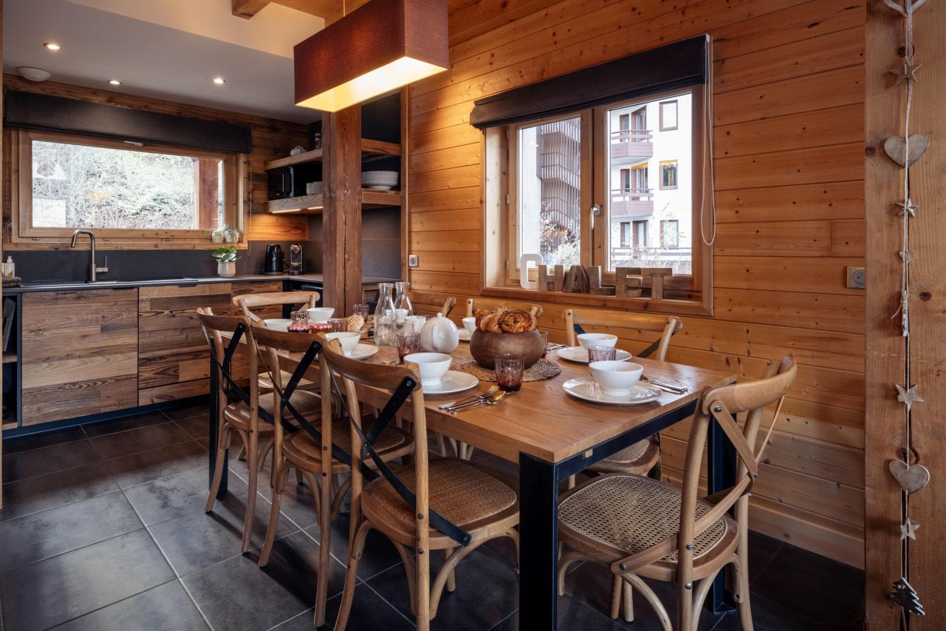 Dining area seats 6 with adjoining kitchenette and timber paneled walls