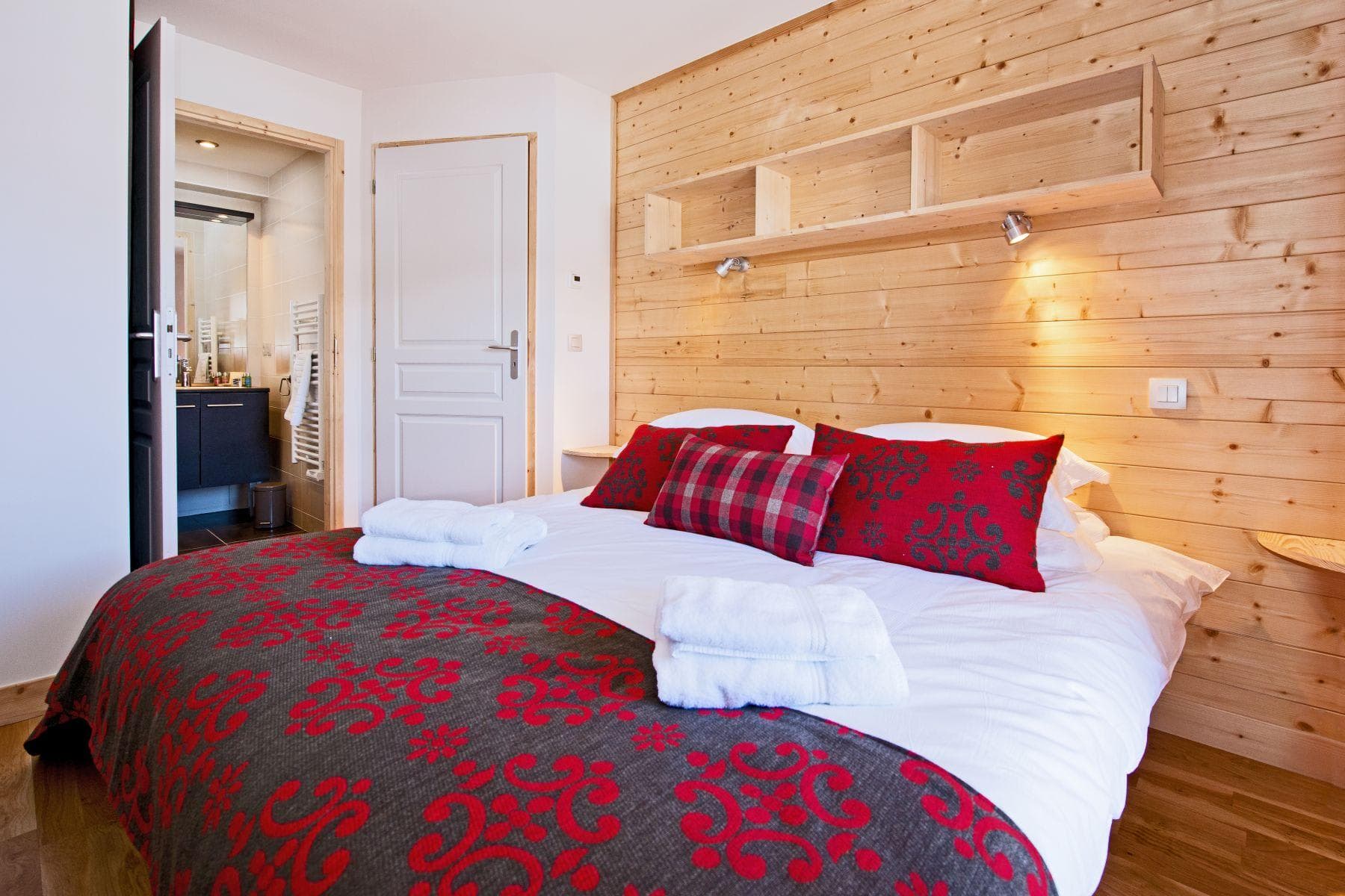 Bedroom with queen bed and ensuite bathroom featuring heated towel rail