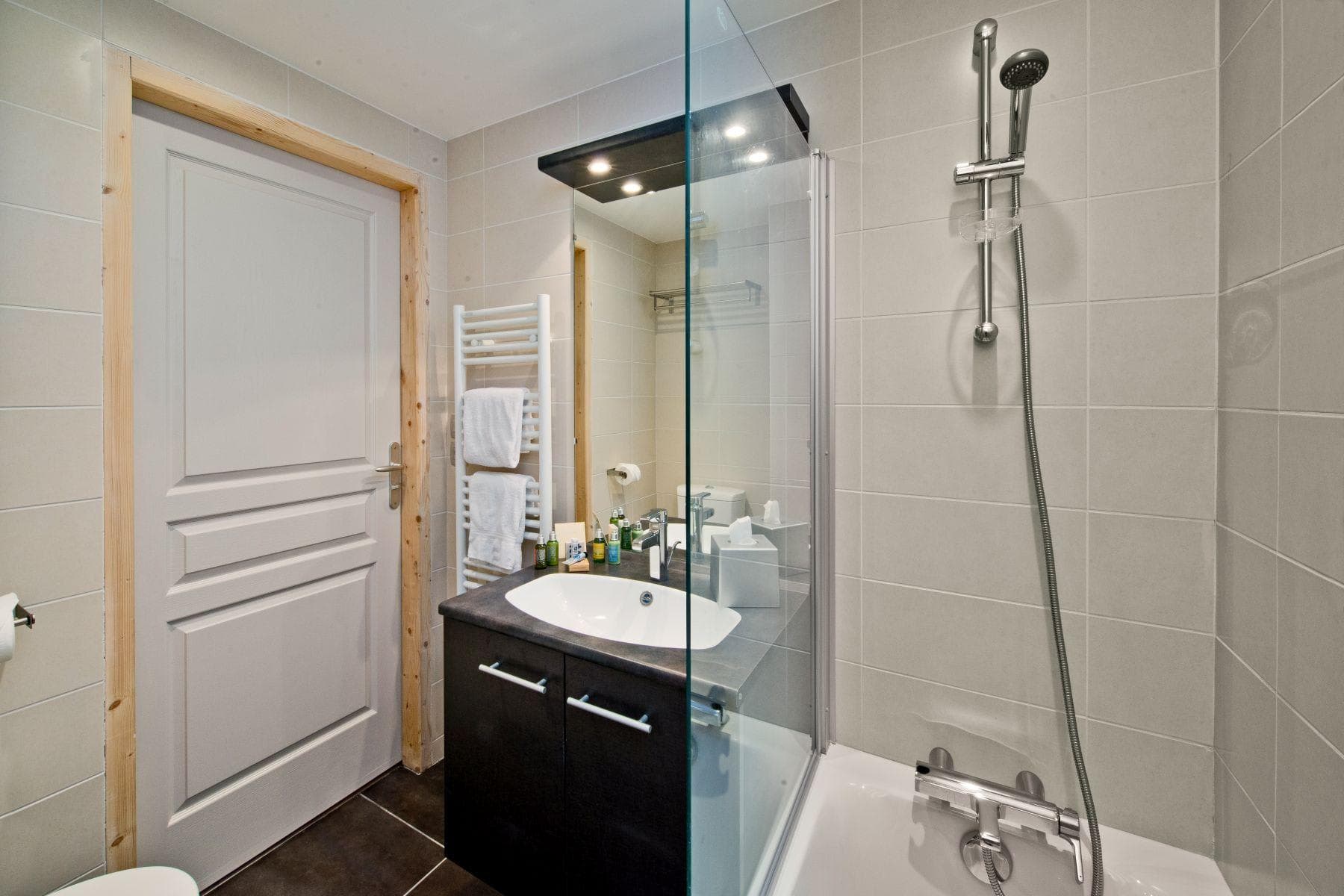 Bathroom with walk-in glass shower and heated towel rail