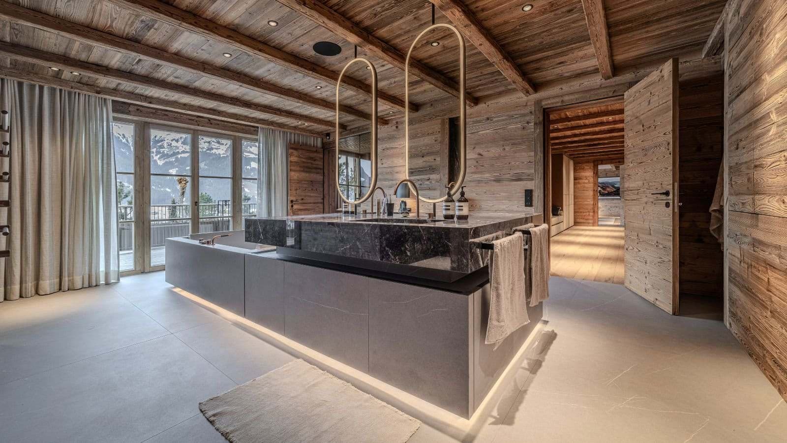 Bathroom with marble island vanity, soaking tub, and mountain views