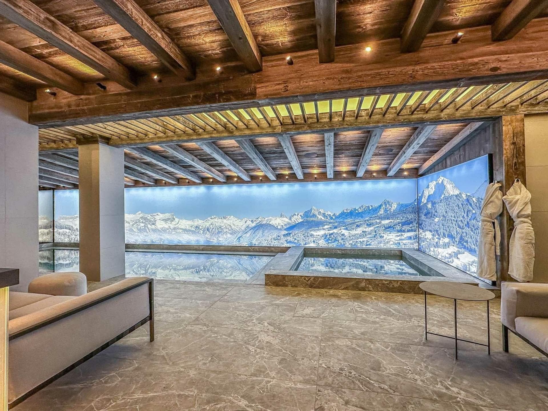 Indoor pool and hot tub with panoramic mountain mural and lounge seating