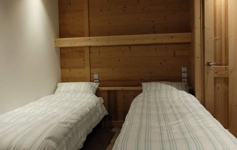 Guest bedroom with two twin beds and integrated reading lights