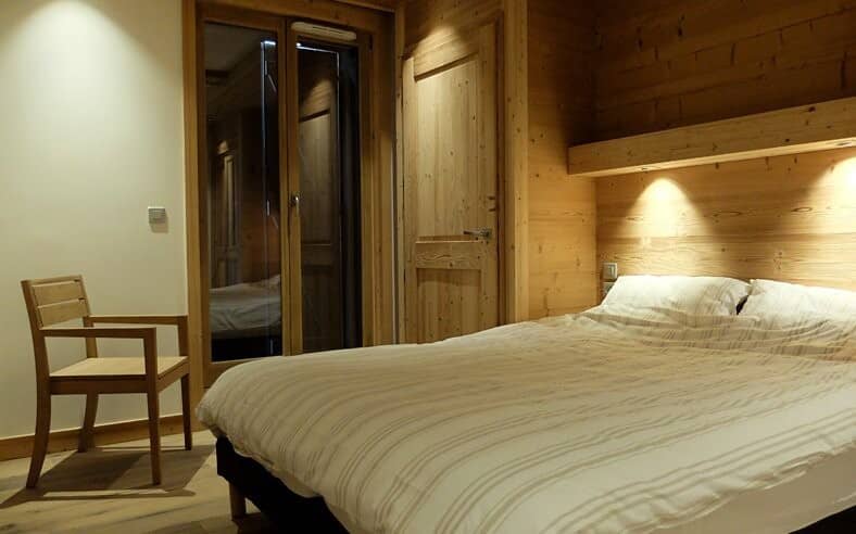Guest bedroom with queen bed and wood-paneled walls