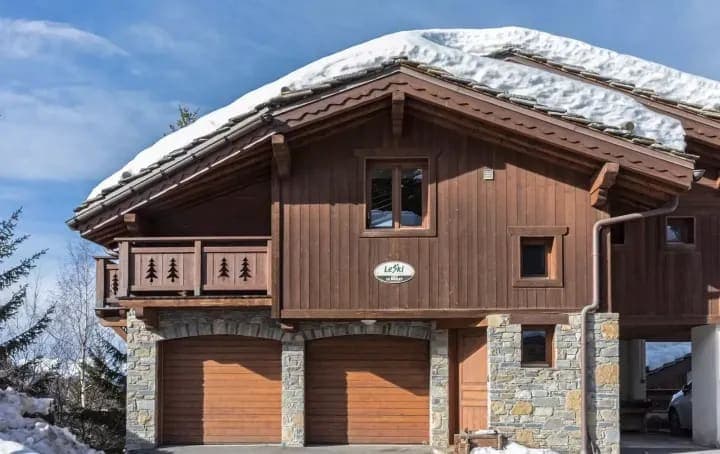 Chalet exterior with two-car garage and private balcony