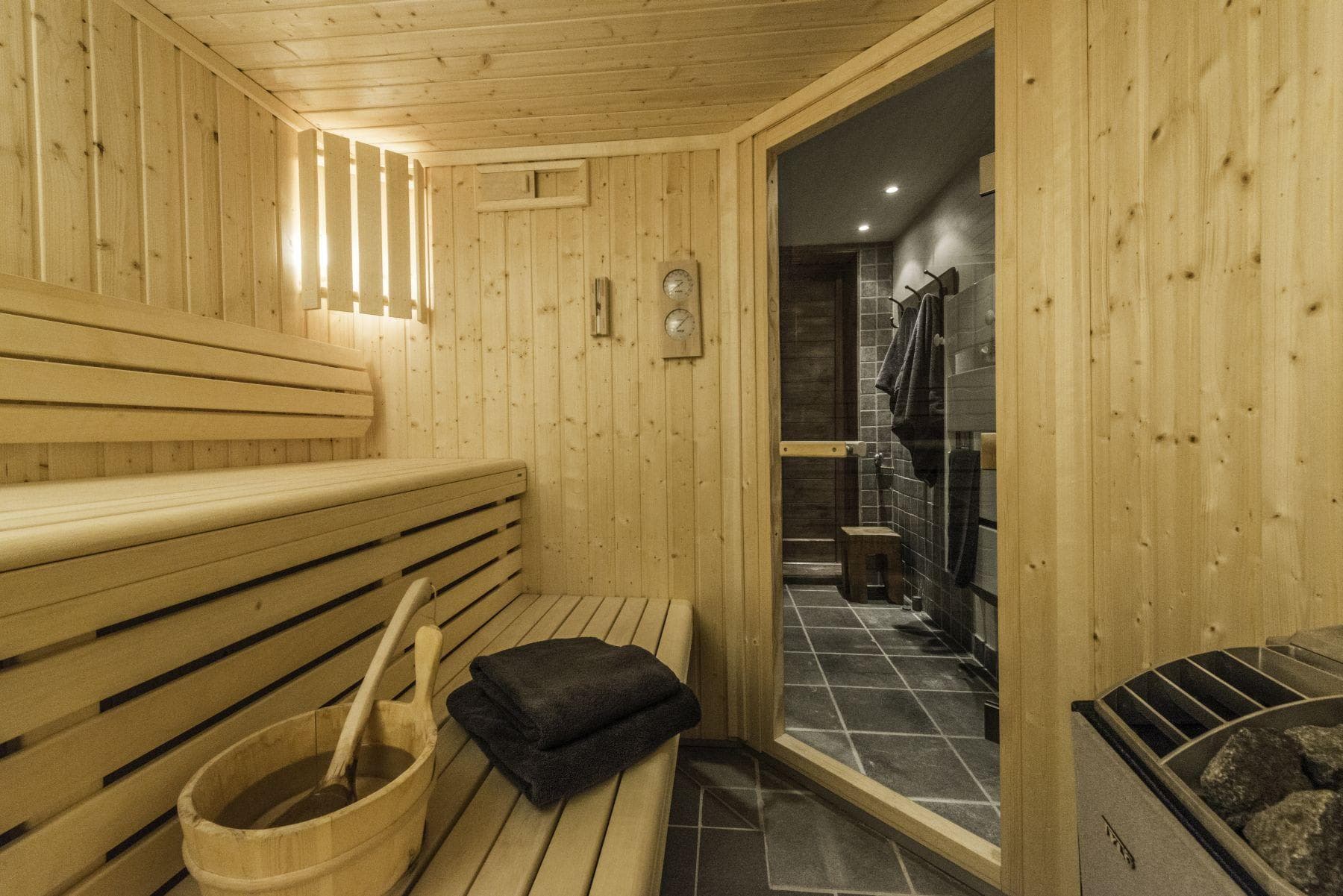 Private cedar sauna with tiered seating and adjacent walk-in shower