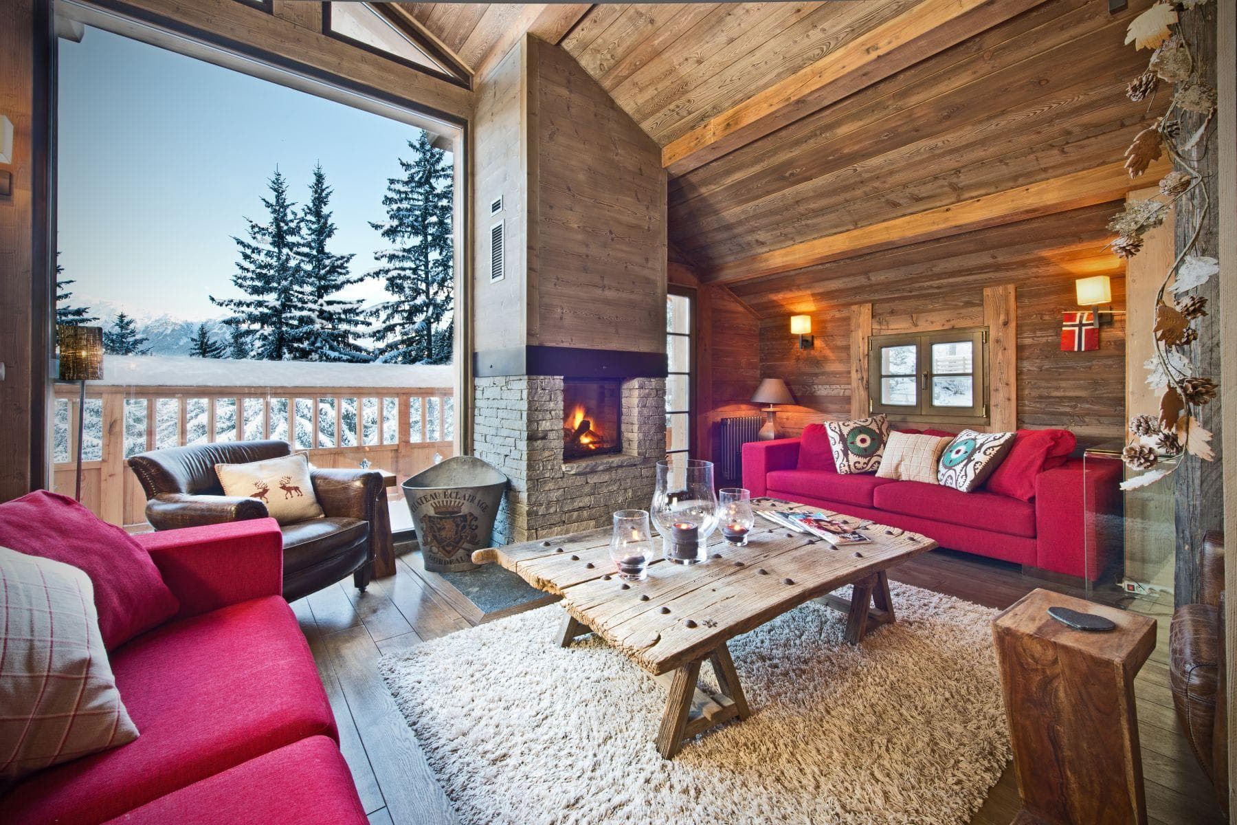 Living area with wood-burning fireplace and floor-to-ceiling mountain views