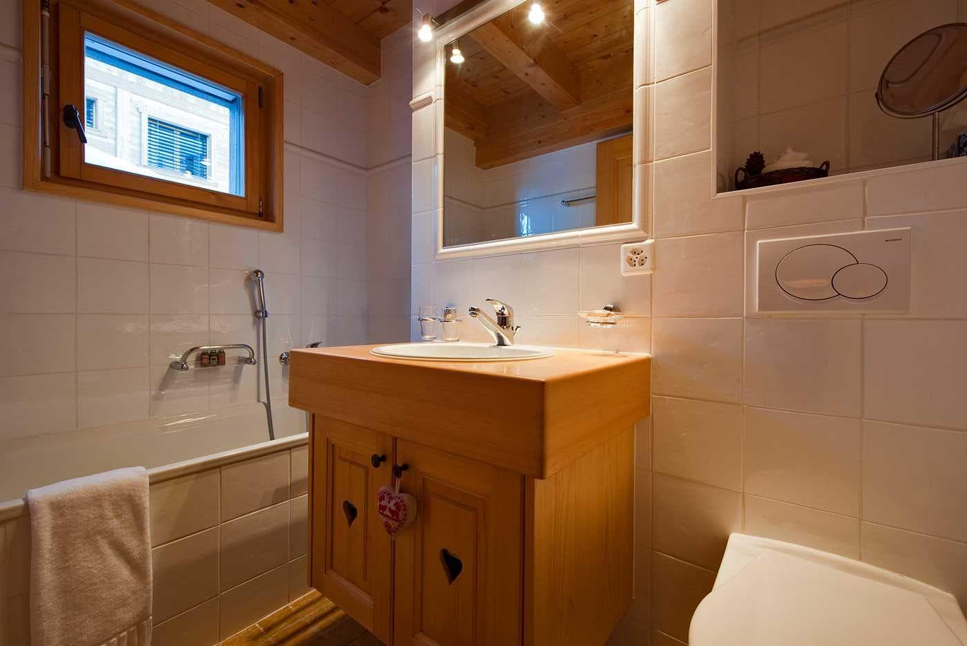 Bathroom with single vanity, toilet, and bathtub with handheld sprayer