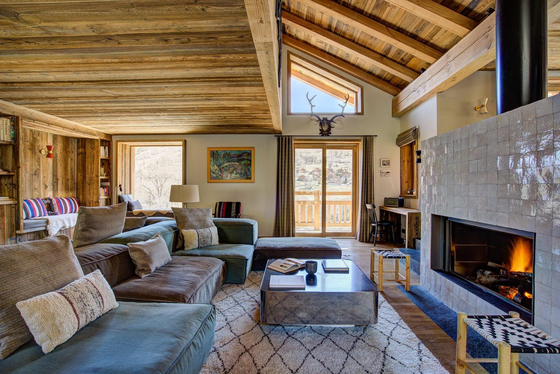 Living room with wood-burning fireplace and sectional seating; valley views