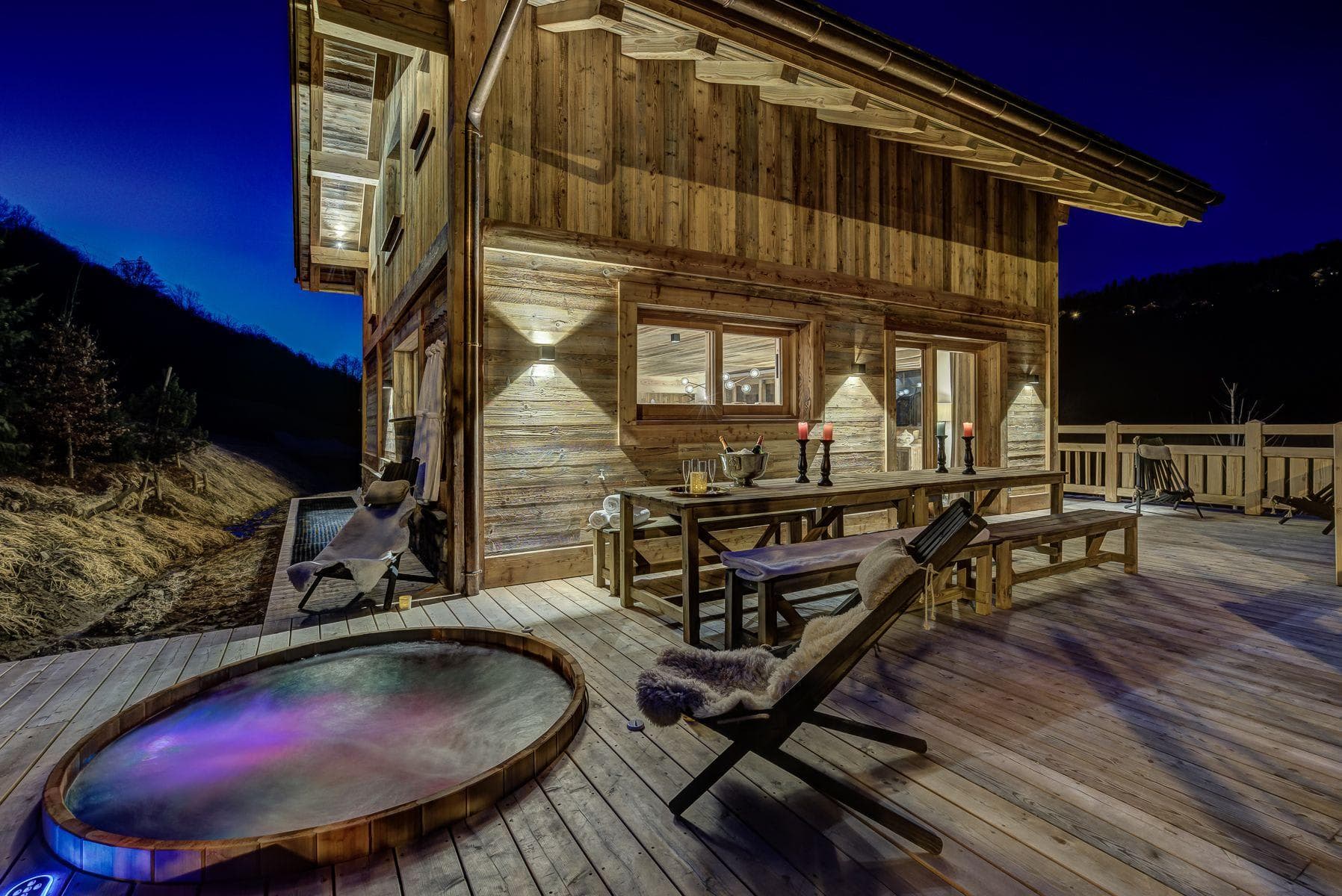 Sunken cedar hot tub and dining area with mountain backdrop