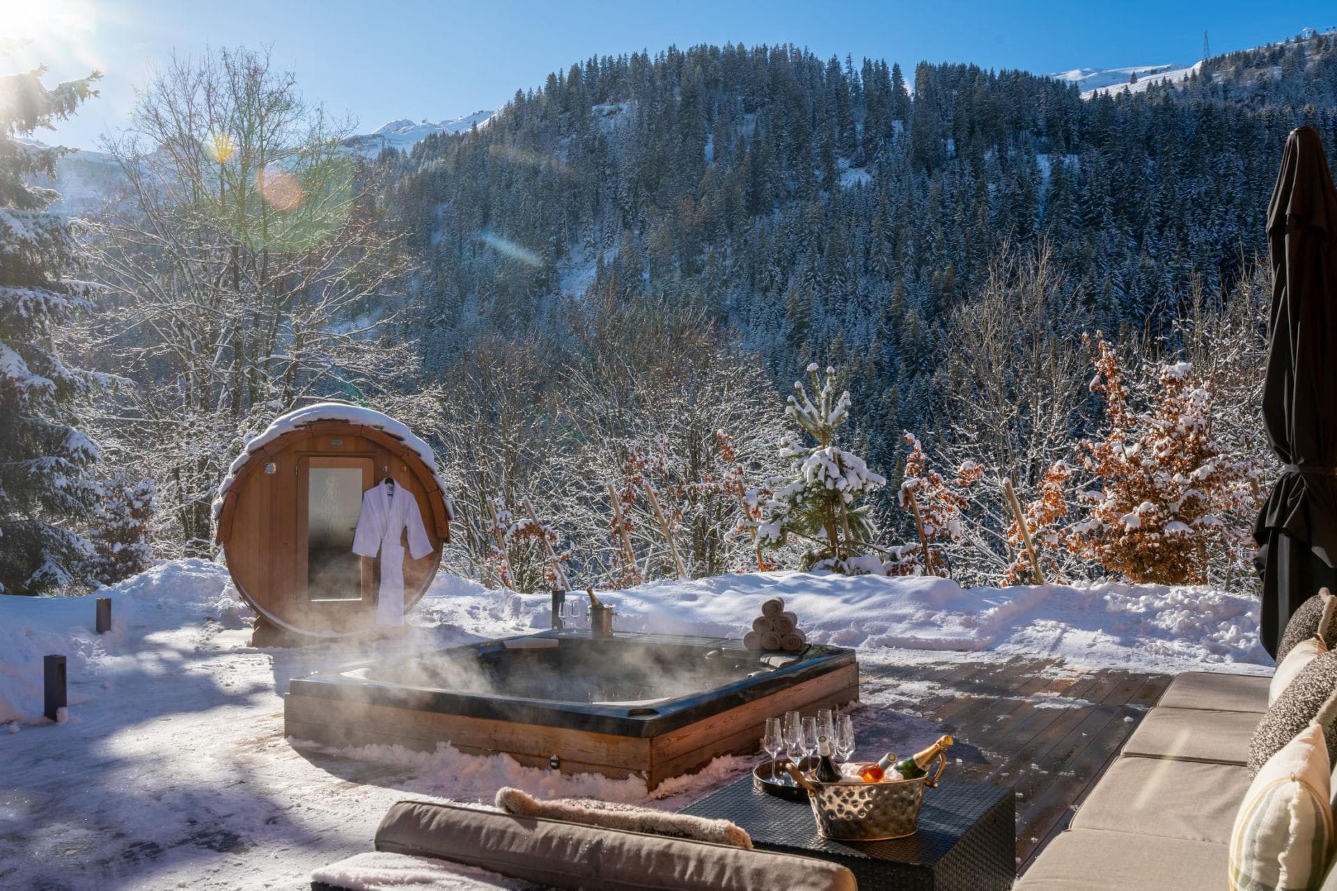 Outdoor hot tub and barrel sauna with mountain forest views