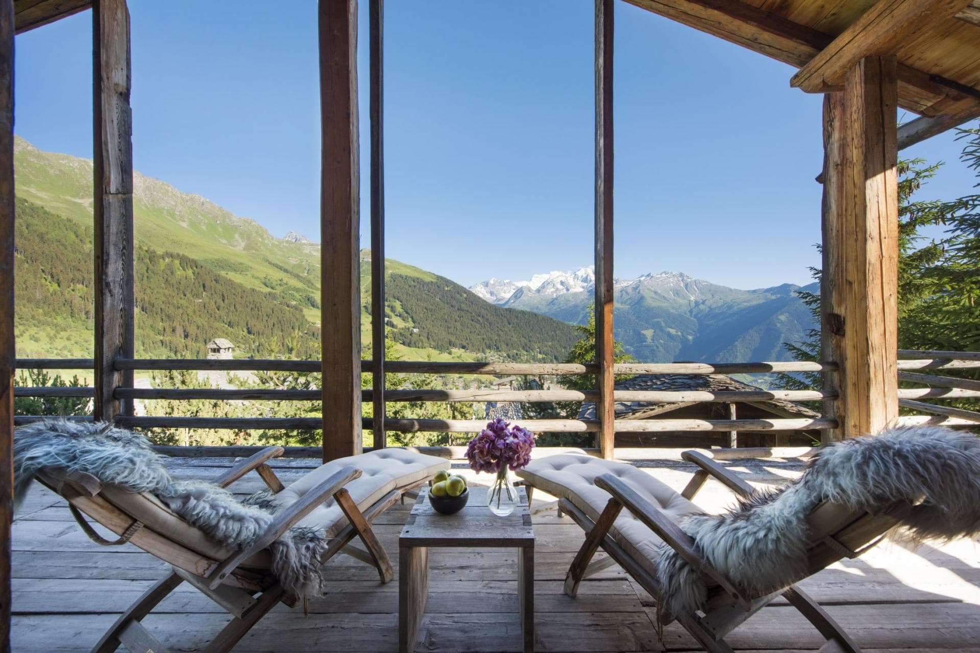 Covered timber balcony with lounge seating and panoramic Mont Blanc views