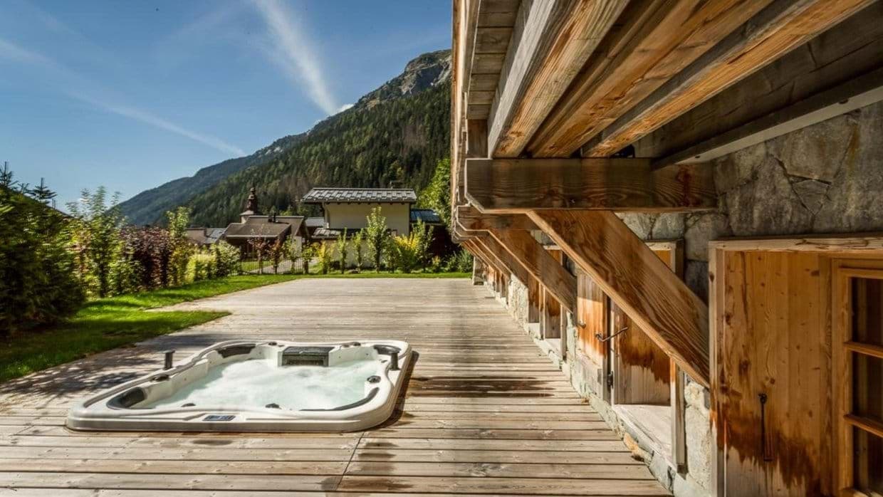 Sunken hot tub on wooden deck with mountain views