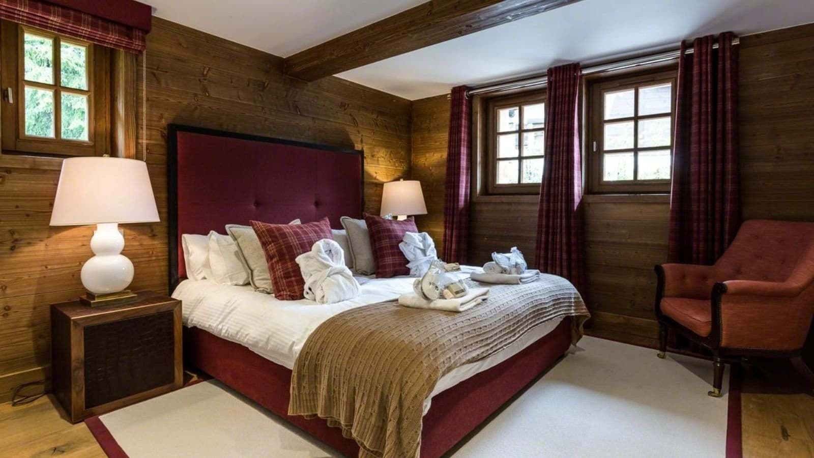Bedroom with king bed and wood-paneled walls