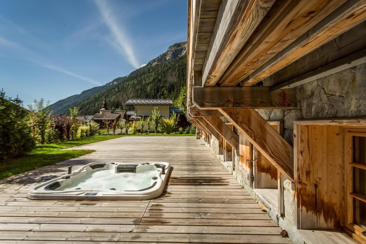 Sunken outdoor hot tub on timber deck with mountain views