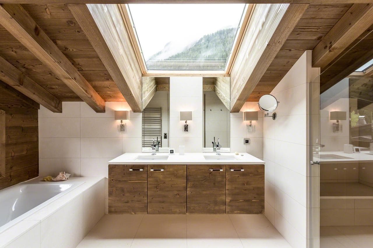 Bathroom with double vanity, soaking tub, and mountain-view skylight