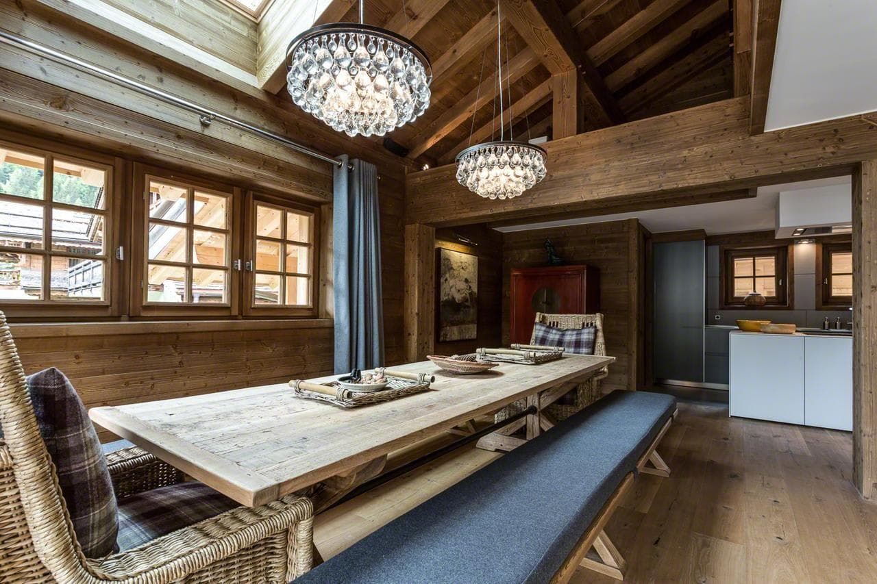 Dining area with bench seating and adjacent kitchenette; vaulted timber ceilings