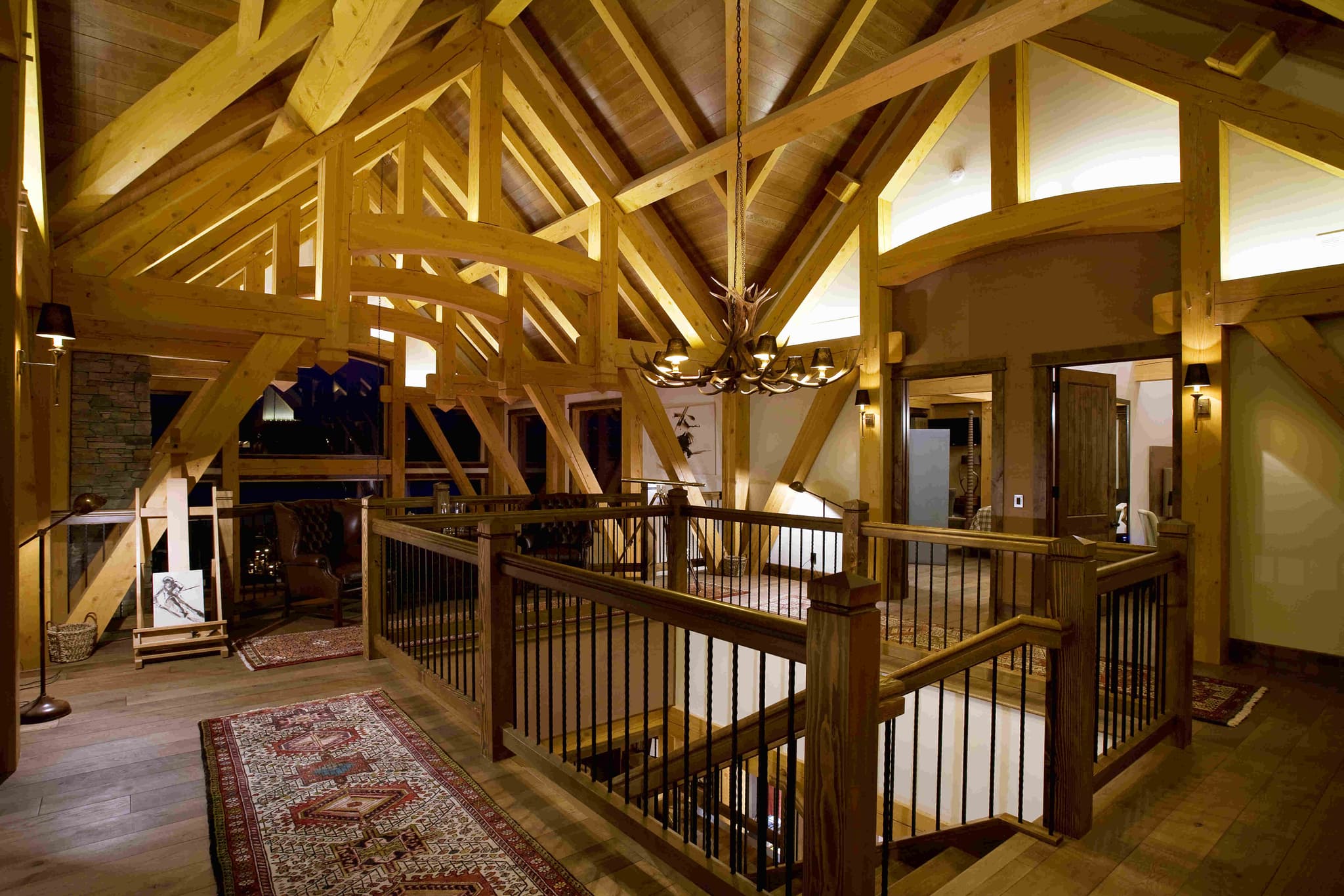 Upper level landing with exposed timber trusses and antler chandelier