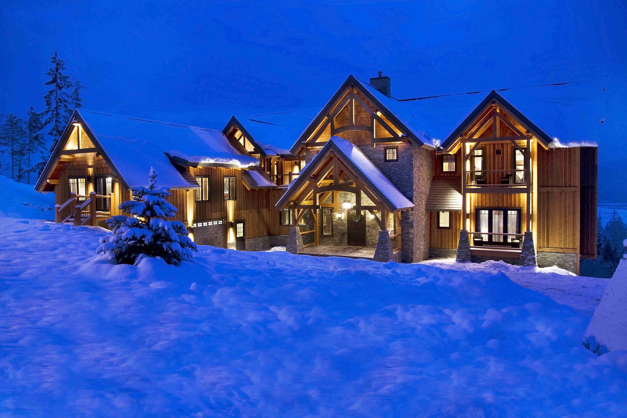 Ski-in lodge exterior featuring timber framing and heated three-car garage