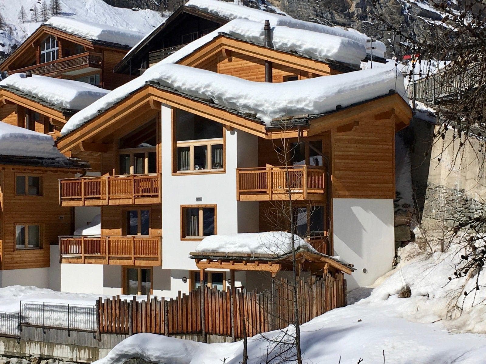 Three-story chalet exterior with multiple balconies and private fenced patio
