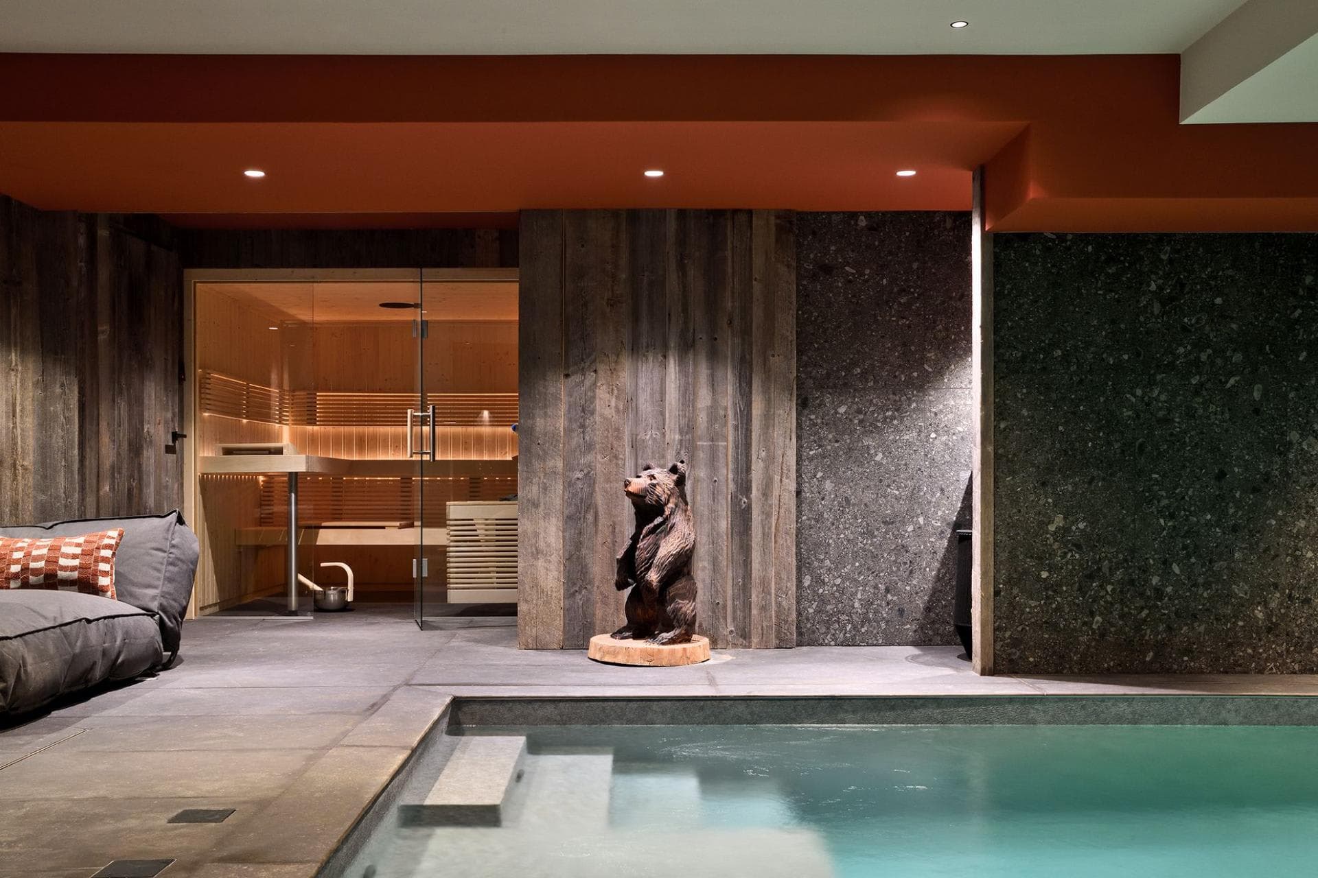 Indoor pool with sauna, steam room, and carved bear sculpture; radiant heated floors