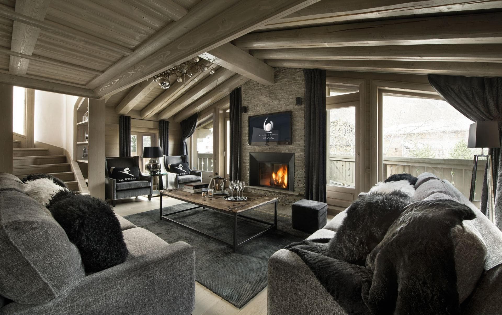 Living area with stone fireplace and access to private balcony