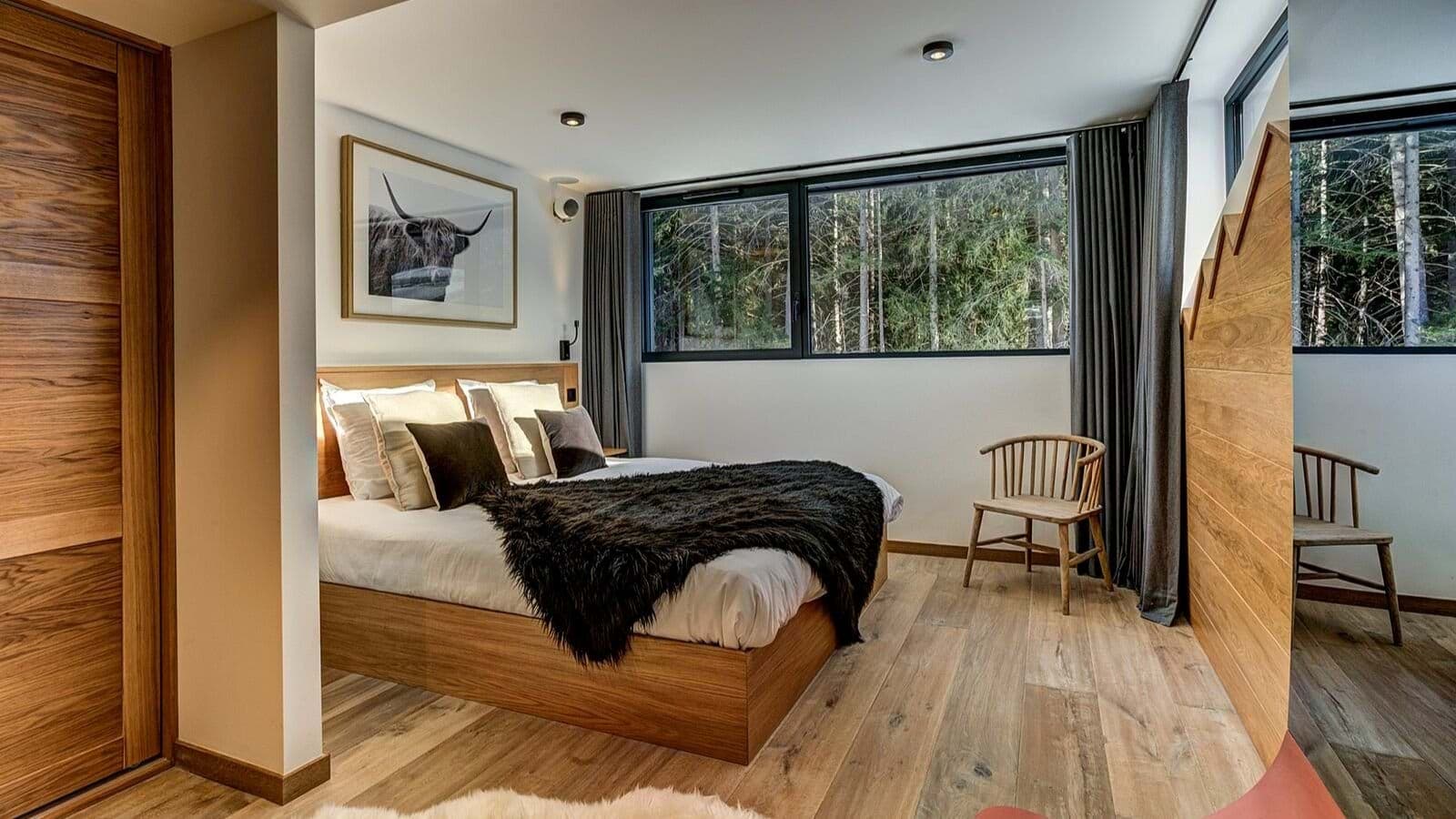 Bedroom with queen bed, forest view, and built-in wood wardrobes
