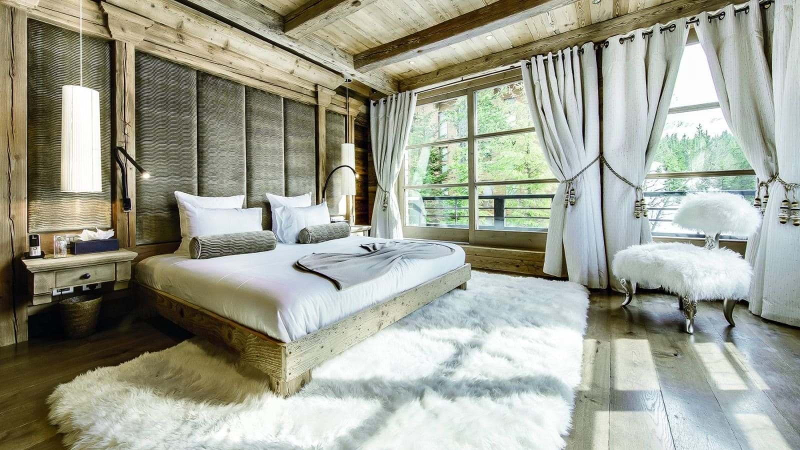 Primary bedroom with king bed, forest views, and heated wood floors