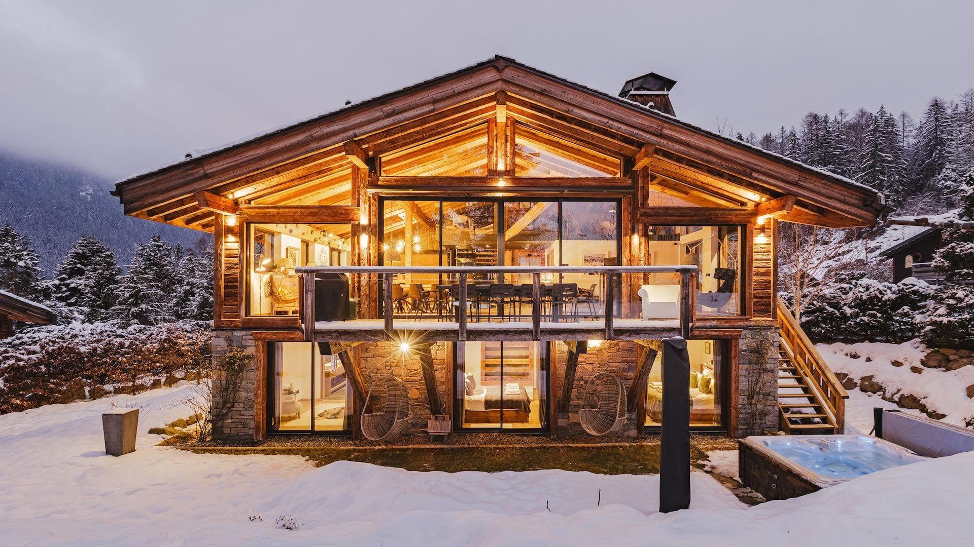 Mountain lodge exterior with heated hot tub and valley views; stone foundation