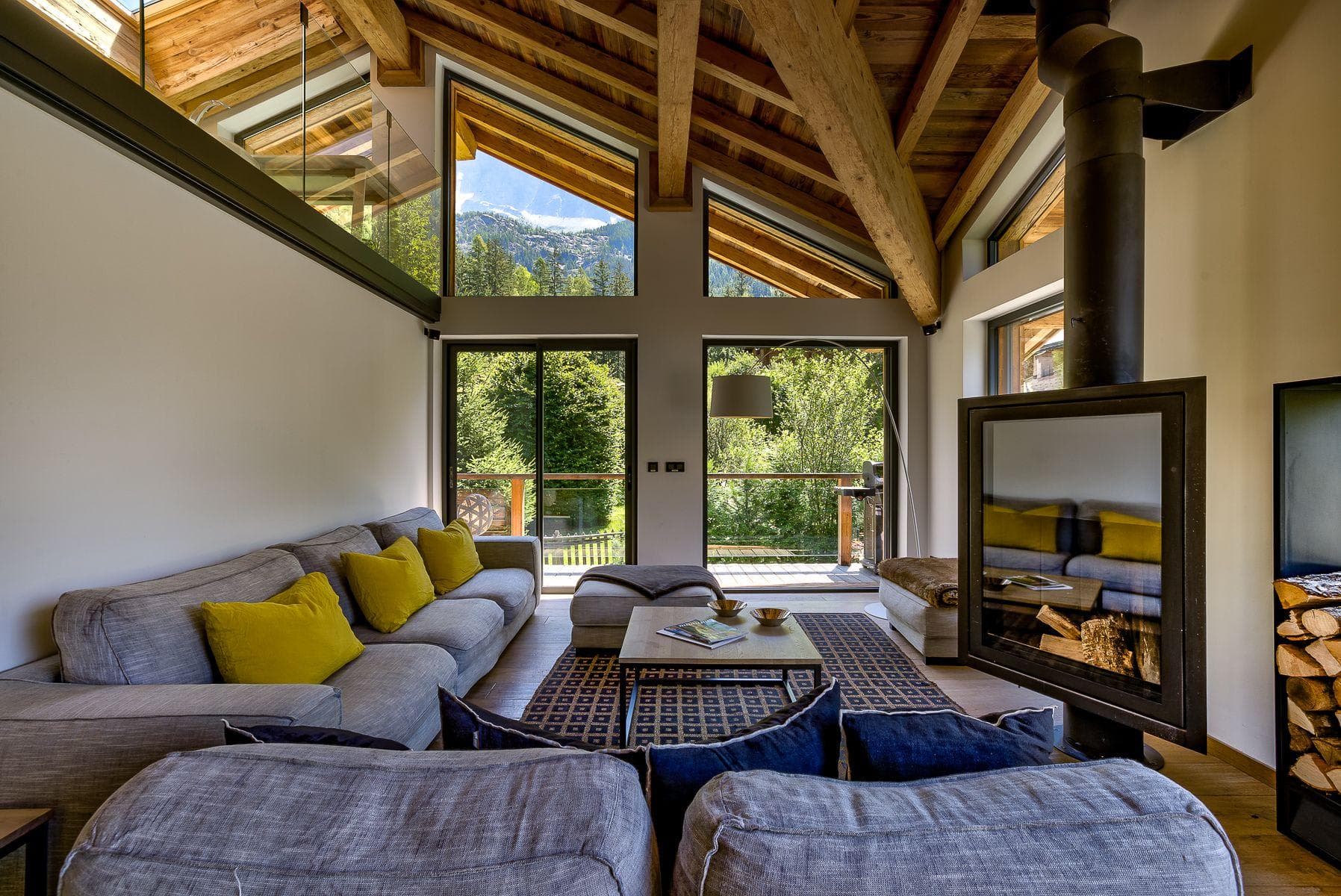 Living area with wood-burning fireplace and floor-to-ceiling mountain views