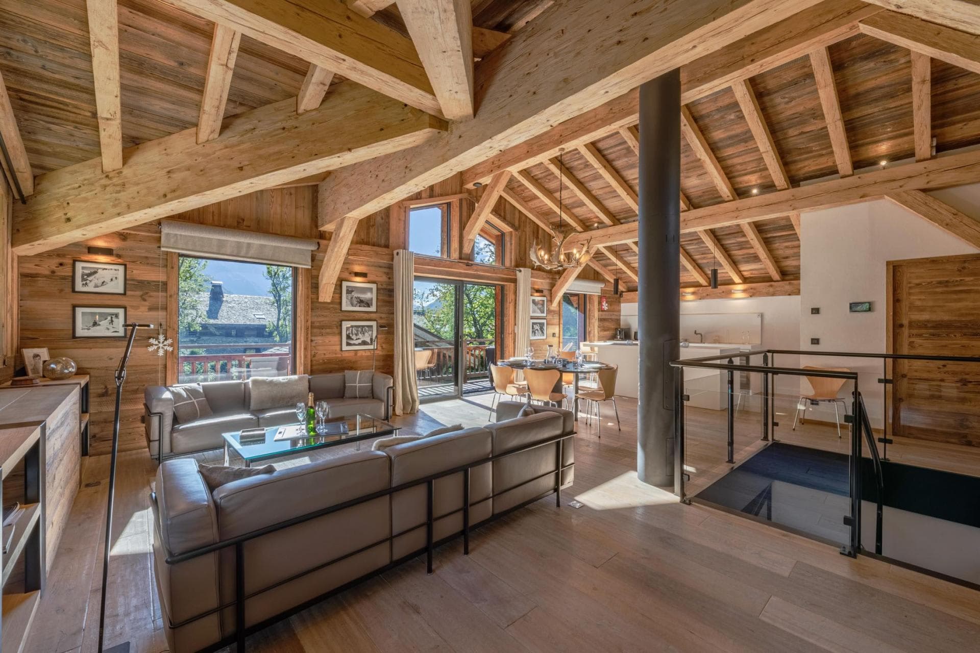 Open-plan living area with vaulted beam ceilings and balcony access
