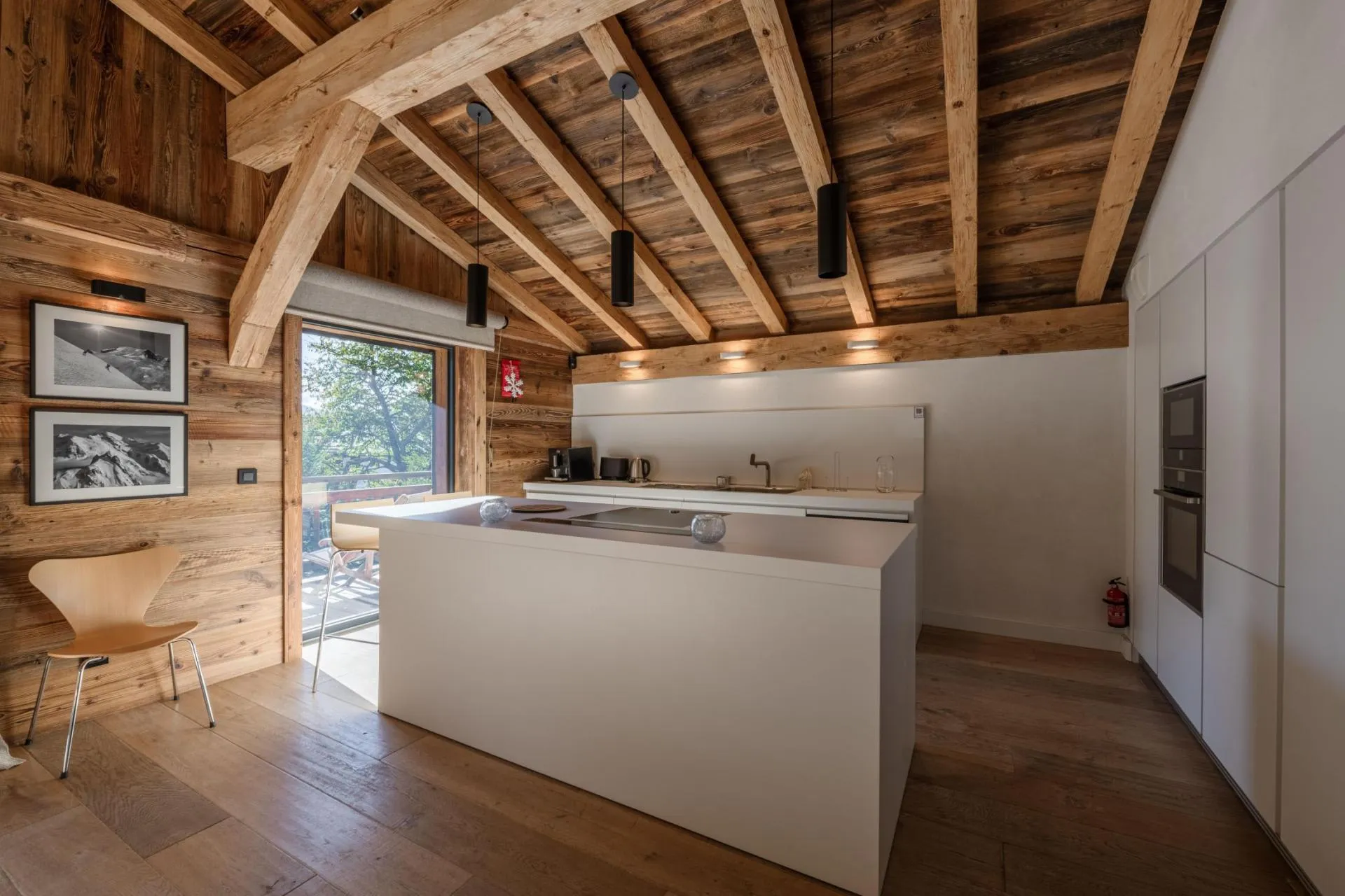 Open fitted kitchen with island beneath exposed timber beams