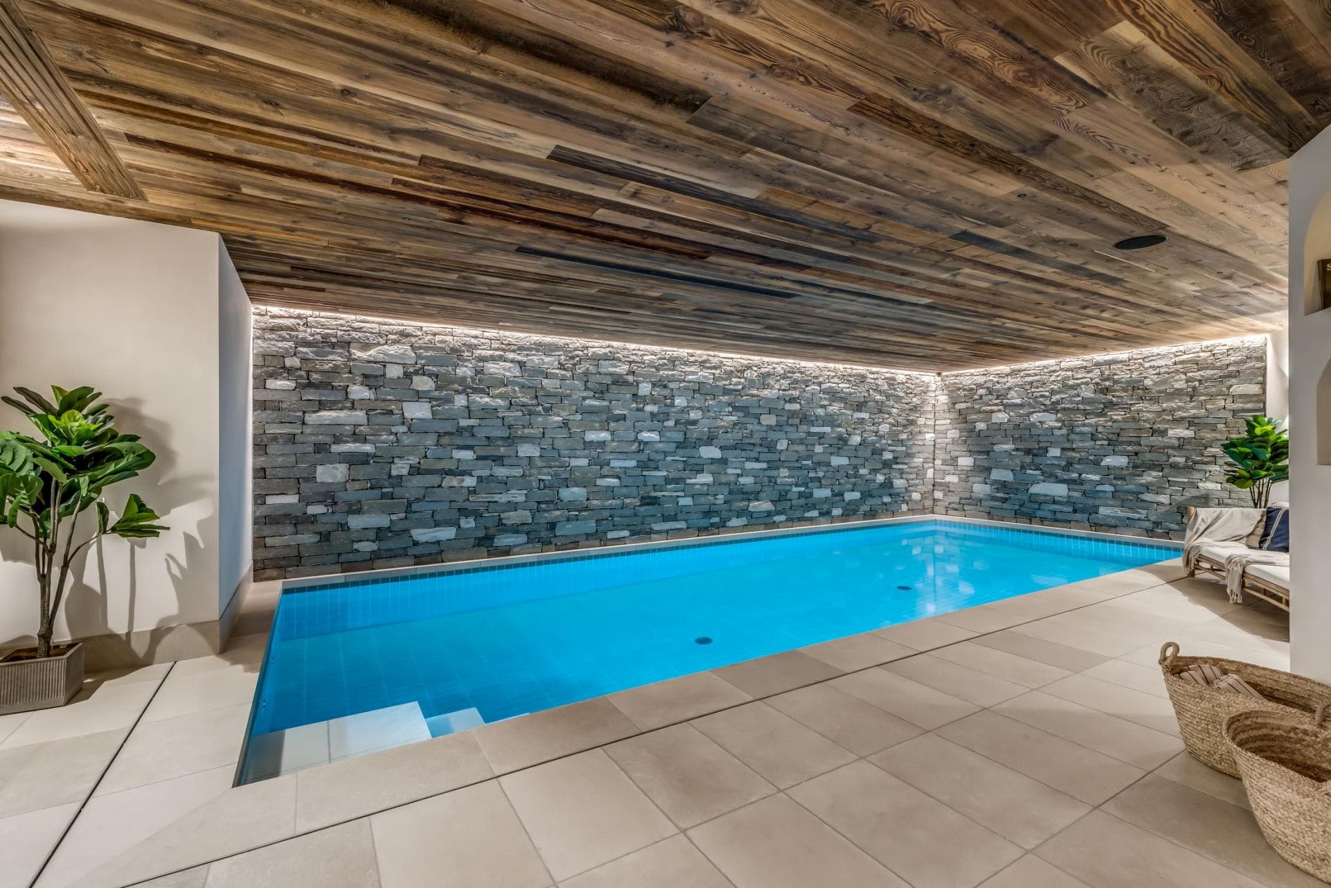Indoor pool featuring reclaimed wood ceiling and stone accent wall