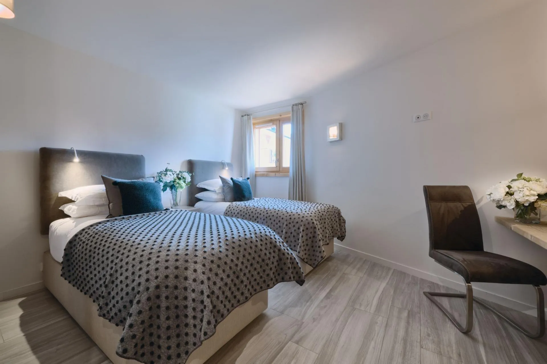 Twin bedroom with integrated reading lights and desk workspace