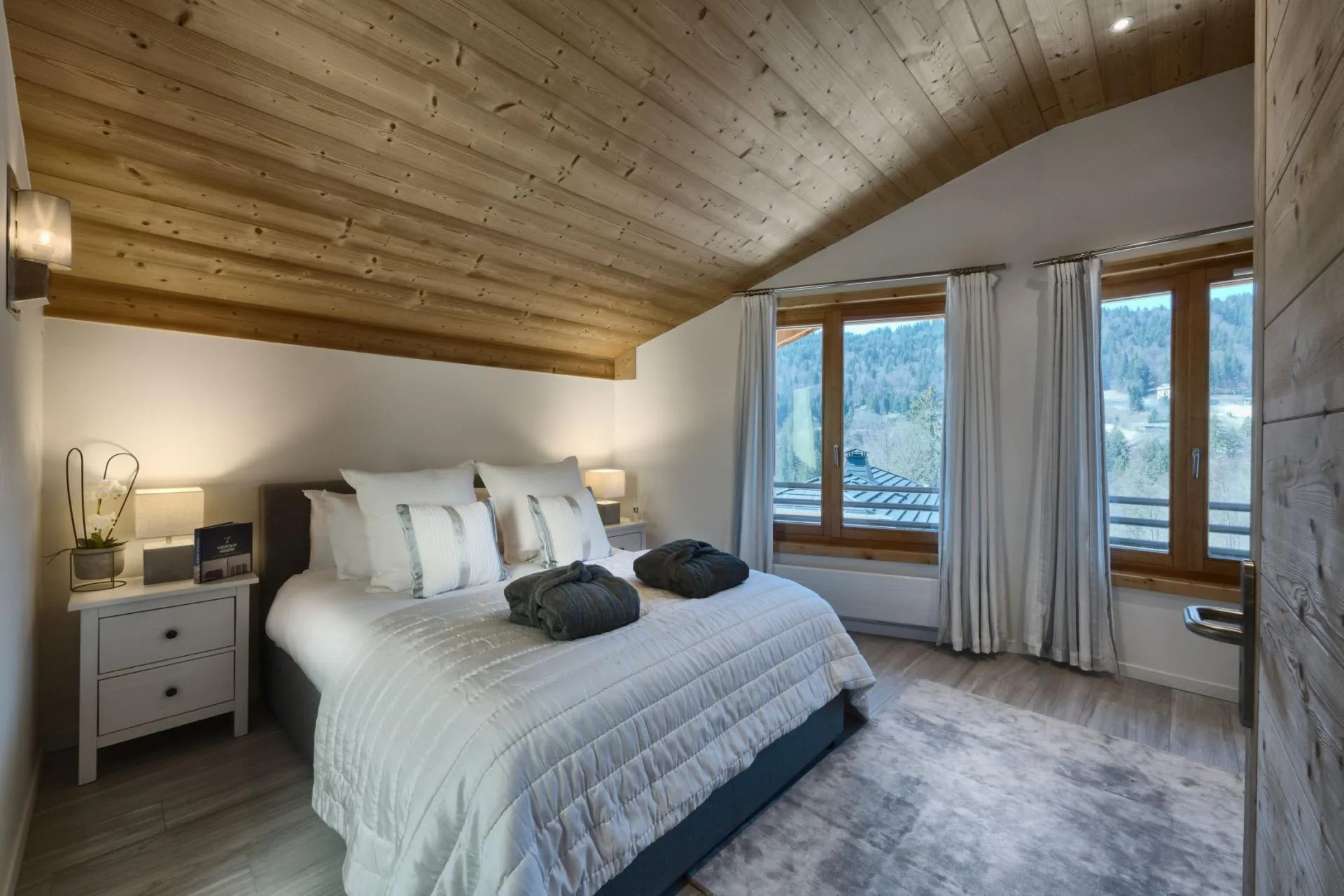 Bedroom with king bed and sloped wood-paneled ceiling