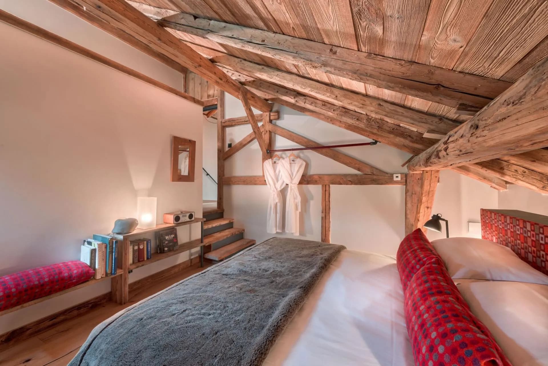 Upper-level bedroom with exposed timber beams and sloped ceiling