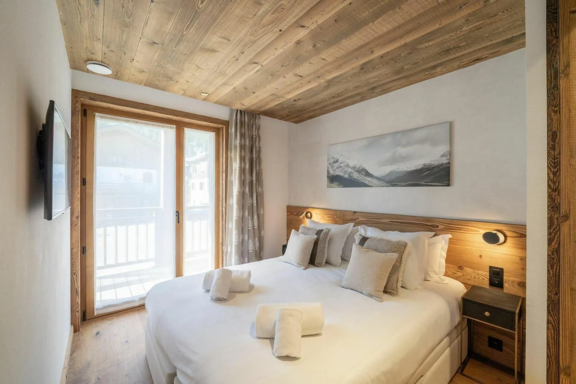 Double bedroom with balcony doors and mountain artwork