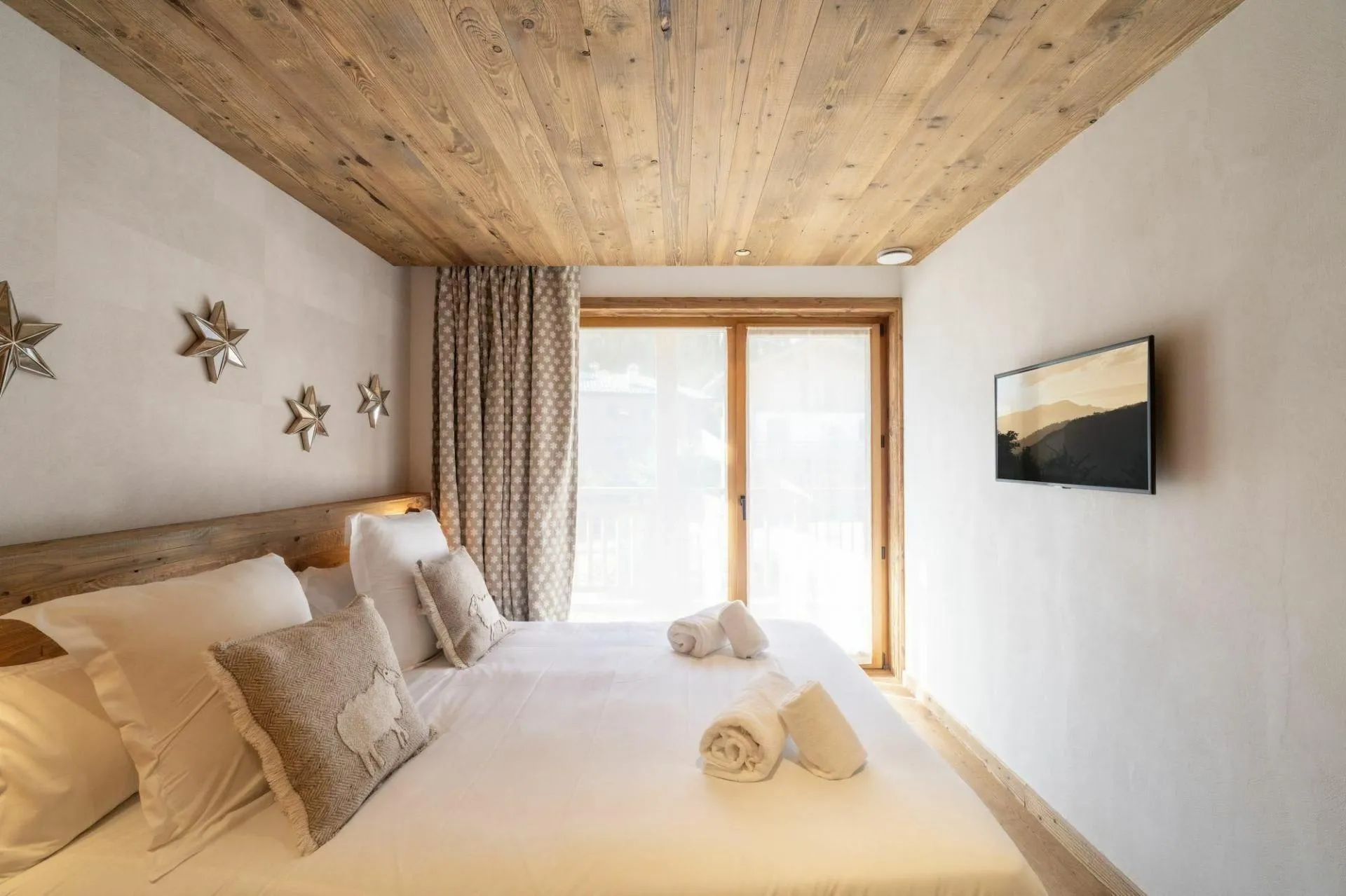 Double bedroom with television and balcony doors