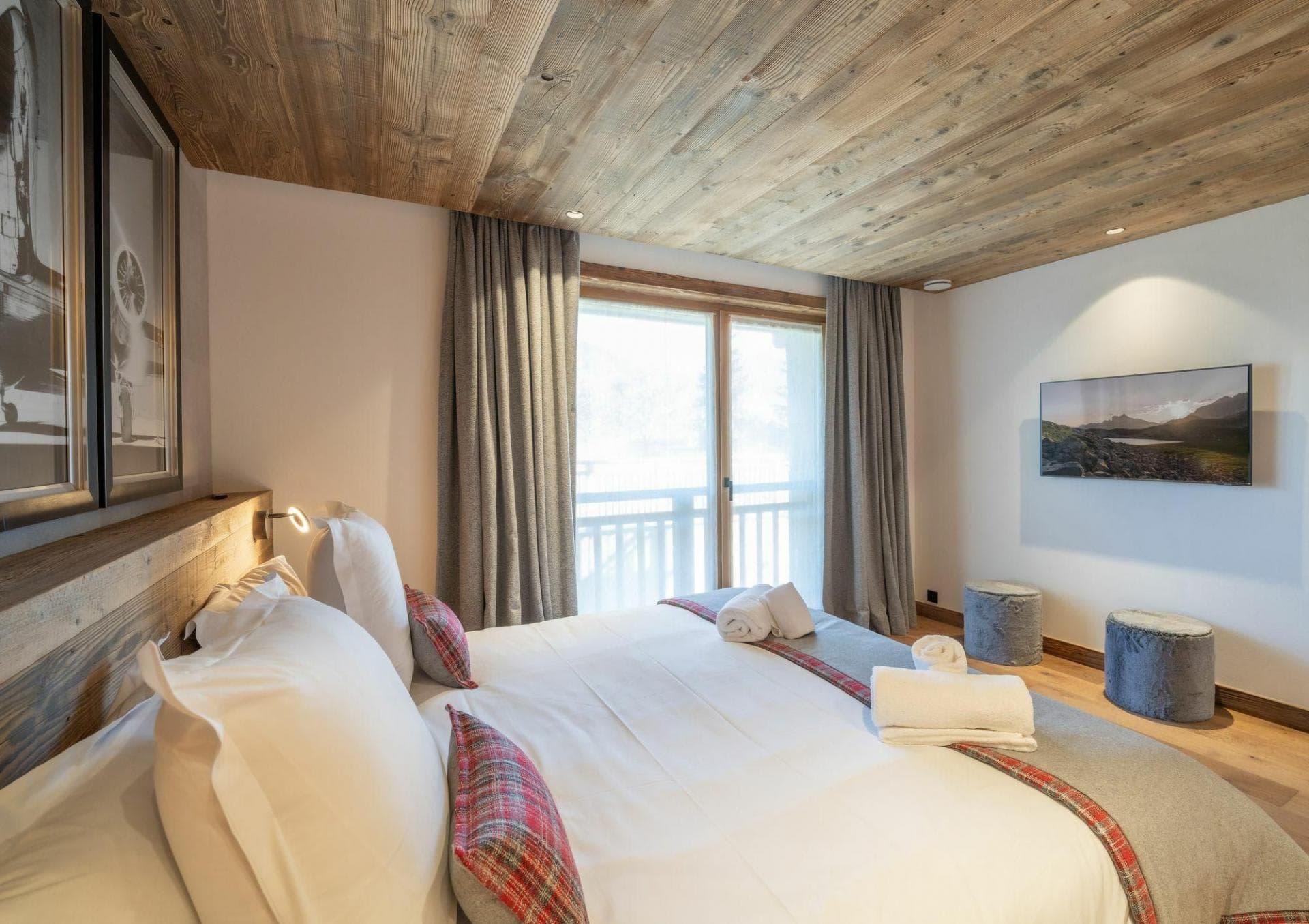 Guest bedroom with king bed, reclaimed wood ceiling, and balcony access